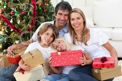 Happy family holding Christmas gifts