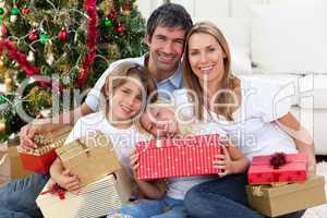 Happy family holding Christmas gifts