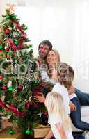 Happy family decorating a Christmas tree