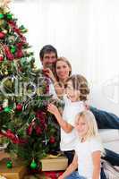 Parents and their children decorating a Christmas tree