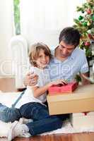 Little boy opening Christmas gifts with his father