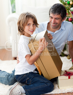 Happy Father and his son opening Christmas gifts