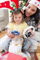 Mother and daughter playing with Christmas presents