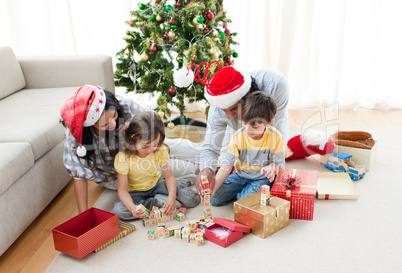 Family playing with Christmas presents at home
