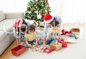 Family playing with Christmas presents at home