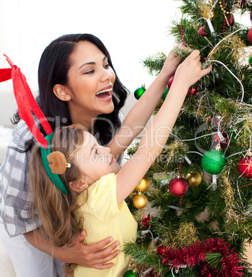 Mother and daughter decorating a Christmas tree