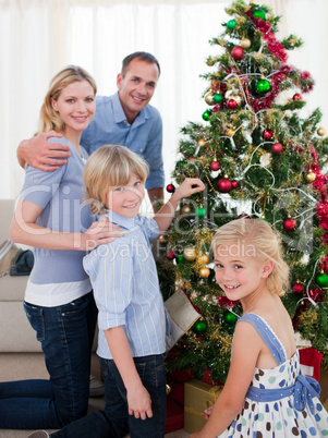 Portrait of a young family decorating a Christmas tree