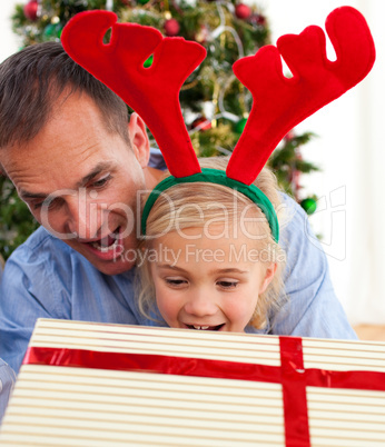 Father and his daughter opening Christmas gifts