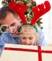 Father and his daughter opening Christmas gifts