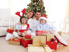 Happy family holding Christmas gifts