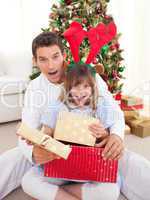 Surprised father and his girl opening Christmas gifts