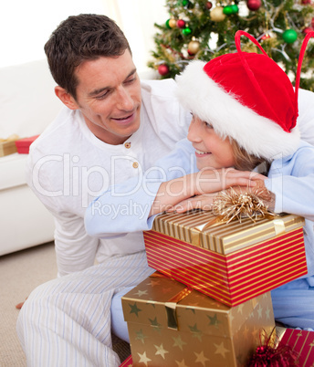 Smiling father and his son unpacking Christmas gifts