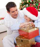 Smiling father and his son unpacking Christmas gifts