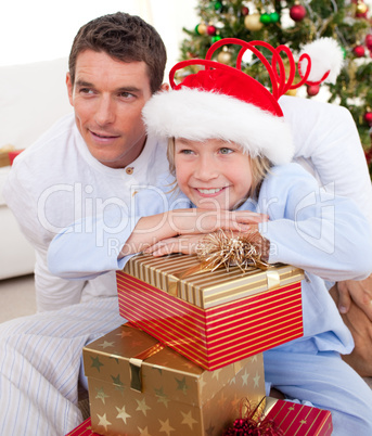 Smiling father and his son holding Christmas gifts