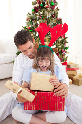 Happy father and his daughter opening Christmas gifts