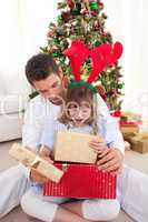 Happy father and his daughter opening Christmas gifts
