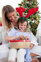 Portrait of a mother and her daughter unpacking Christmas gifts