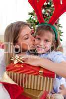 Loving mother kisses daughter at Christmas