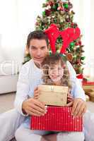 Portrait of a father and his daughter holding Christmas presents