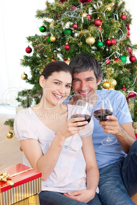 Couple drinking wine at homa at Christmas time
