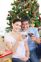 Couple drinking wine at homa at Christmas time