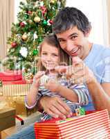 Father and little girl playing with Christmas presents