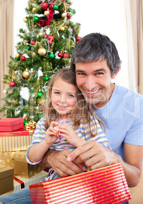 Dad and little girl playing with Christmas presents