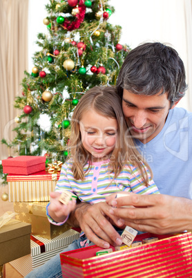 Dad and little girl playing with Christmas presents