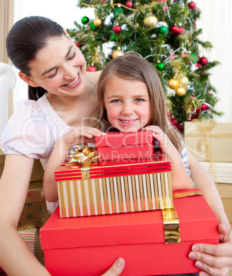 Mother and daughter at home holding a Christmas gift