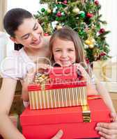 Mother and daughter at home holding a Christmas gift
