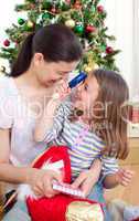 Mother and daughter playing with Christmas gifts