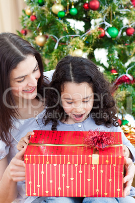 Mother and daughter playing with Christmas gifts