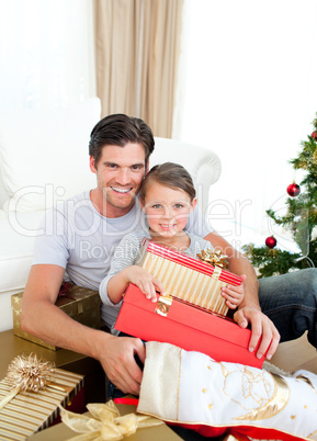 Happy little girl with her father holding a Christmas gift