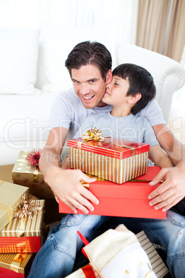 Son kissing his father after receiving a Christmas gift