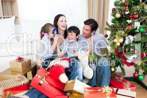 Happy family playing with Christmas gifts