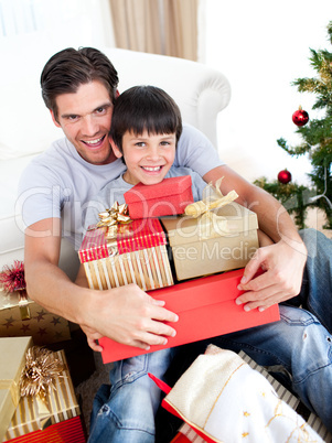 Happy father and son holding Christmas presents