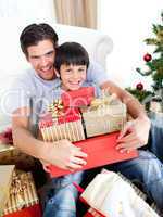 Happy father and son holding Christmas presents