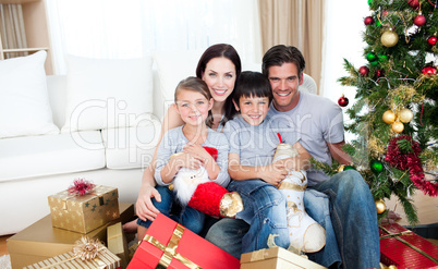 Happy family at Christmas time holding lots of presents