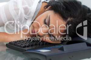 Young businesswoman sleeping on the keyboard