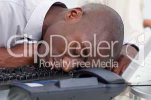 Afro-American businessman sleeping on the keyboard