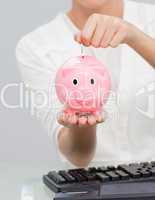 Close-up of a businesswoman saving money in a piggibank