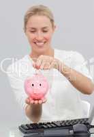 Businesswoman saving money in a piggibank