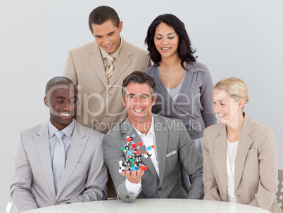 Smiling musiness team holding molecules in the office