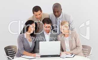 Multi-ethnic business team working with a laptop together