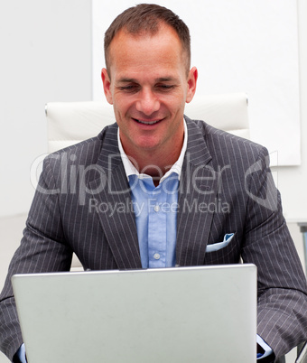 Portrait of smiling businessman on a laptop