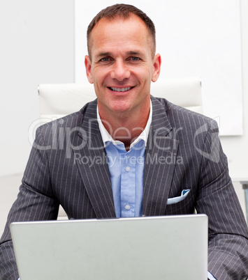 Portrait of smiling businessman on a laptop