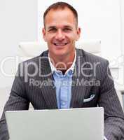 Portrait of smiling businessman on a laptop