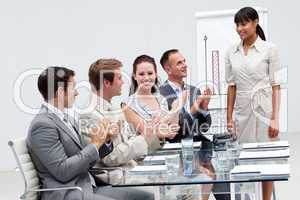 Businesswoman applauding a colleague after giving a presentation