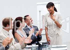 Business team applauding a colleague after giving a presentation