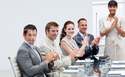 Business people applauding a colleague after reporting to sales